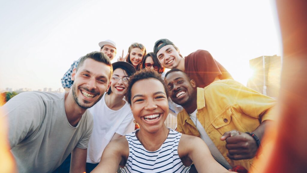 pexels-photo-36729918-36729918 A diverse group of friends taking a joyful selfie outdoors during sunset.